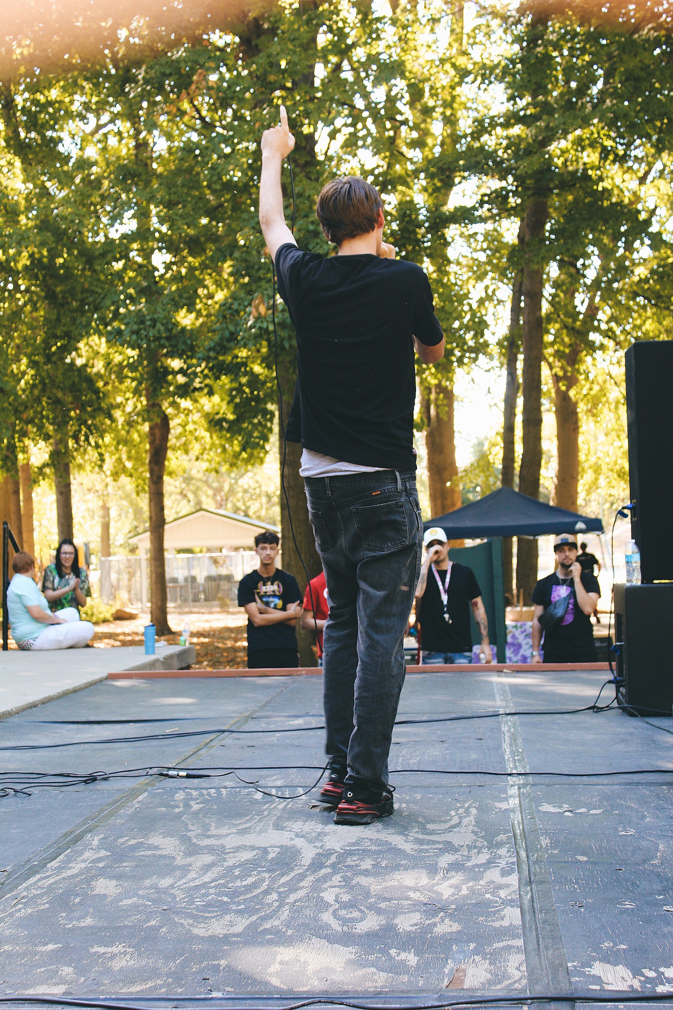 HAKYHM performing outdoors with his back to the crowd