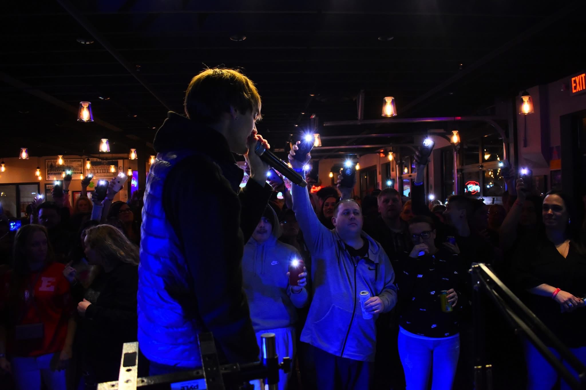 HAKYHM performing with fans holding up phones